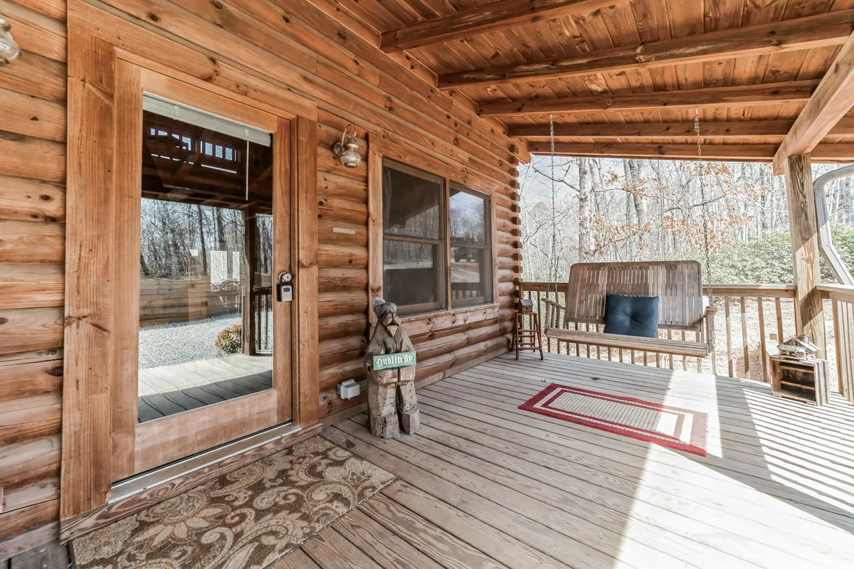 This image captures the front door area with a swinging bench and a decorative figure, evoking a warm and welcoming entryway. The scene hints at being a transition between the outdoors and indoors, with sunrise views, evening breezes, and seasonal decorations visible—elements that reinforce the sense of gathering and arrival.